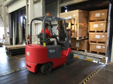 Opérateur déplaçant des colis avec un transpalette